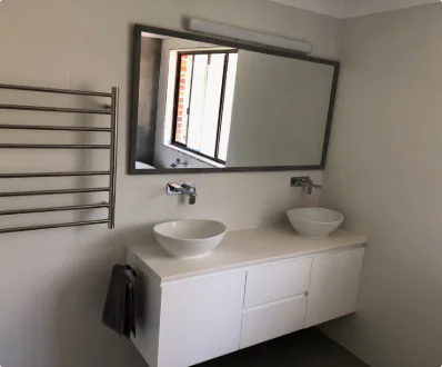 A beautifully renovated bathroom showcasing a contemporary design with elegant fixtures and a spacious layout